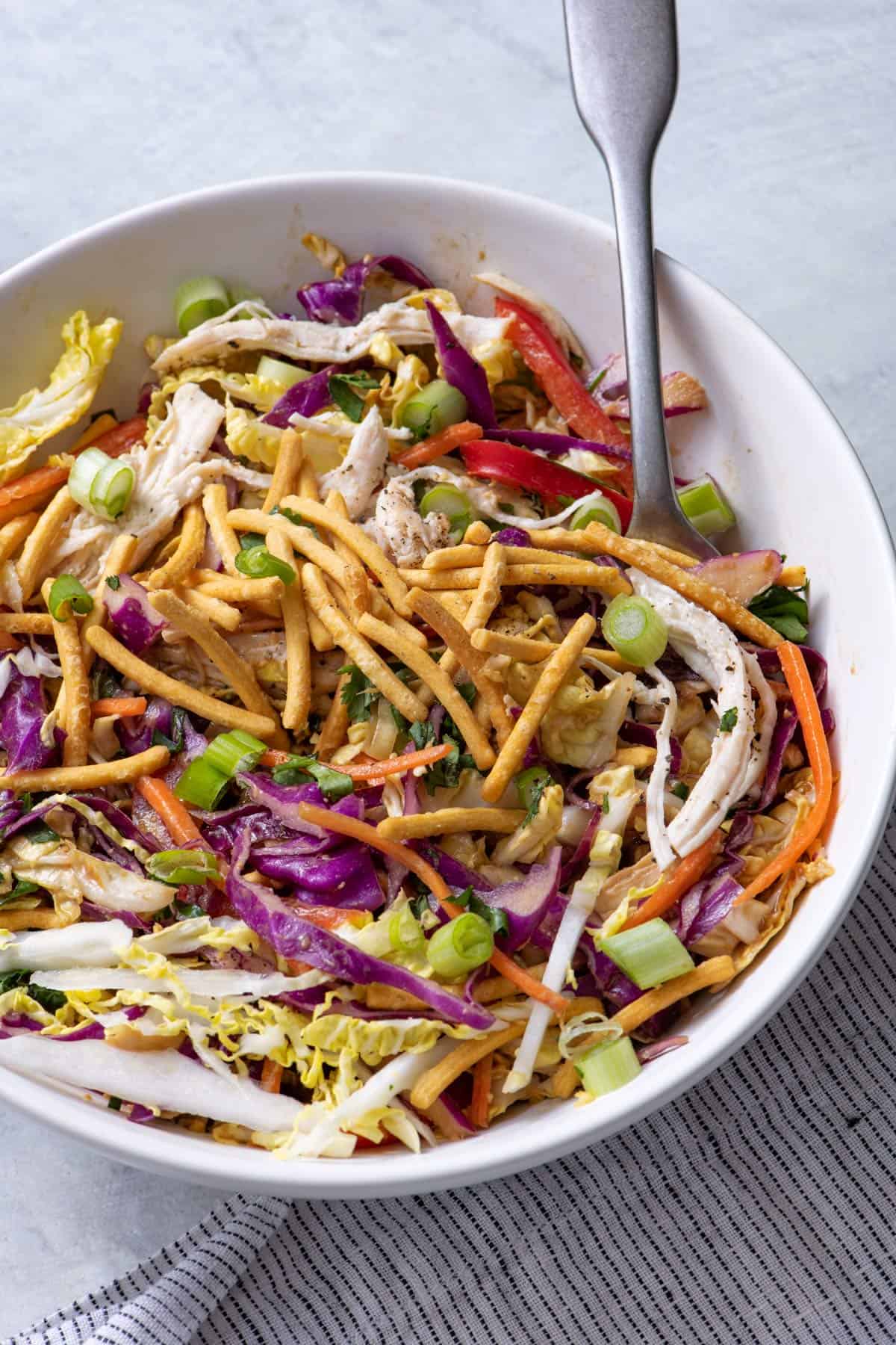 Asian chicken salad topped with sliced green onions