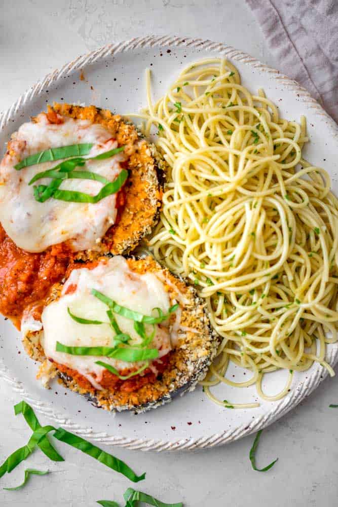 Not your usual fried eggplant Parmesan, this is one is Baked Eggplant Parmesan with no oil! It's coated in gluten-free panko breadcrumbs and Parmesan cheese, and baked in the oven until crispy on the outside and tender on the inside. Serve it with a side of pasta or salad for a healthy, flavorful weeknight dinner!