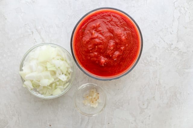 3 ingredients for making marinara sauce: onions, garlic and crushed tomatoes