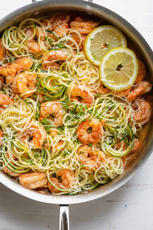 Healthy shrimp scampi made with half pasta and half zucchini topped with lemon slices