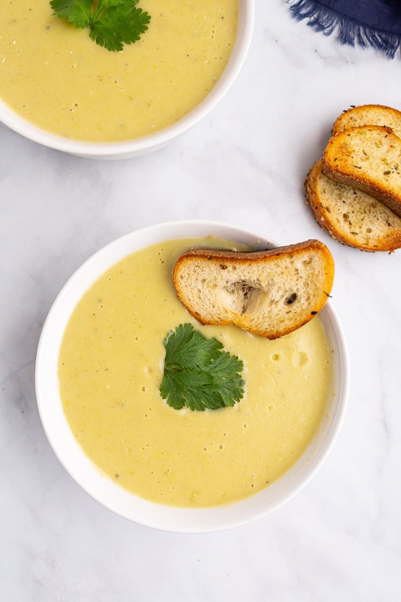  healthy potato leek soup in a bowl with a slice of toasted bread 