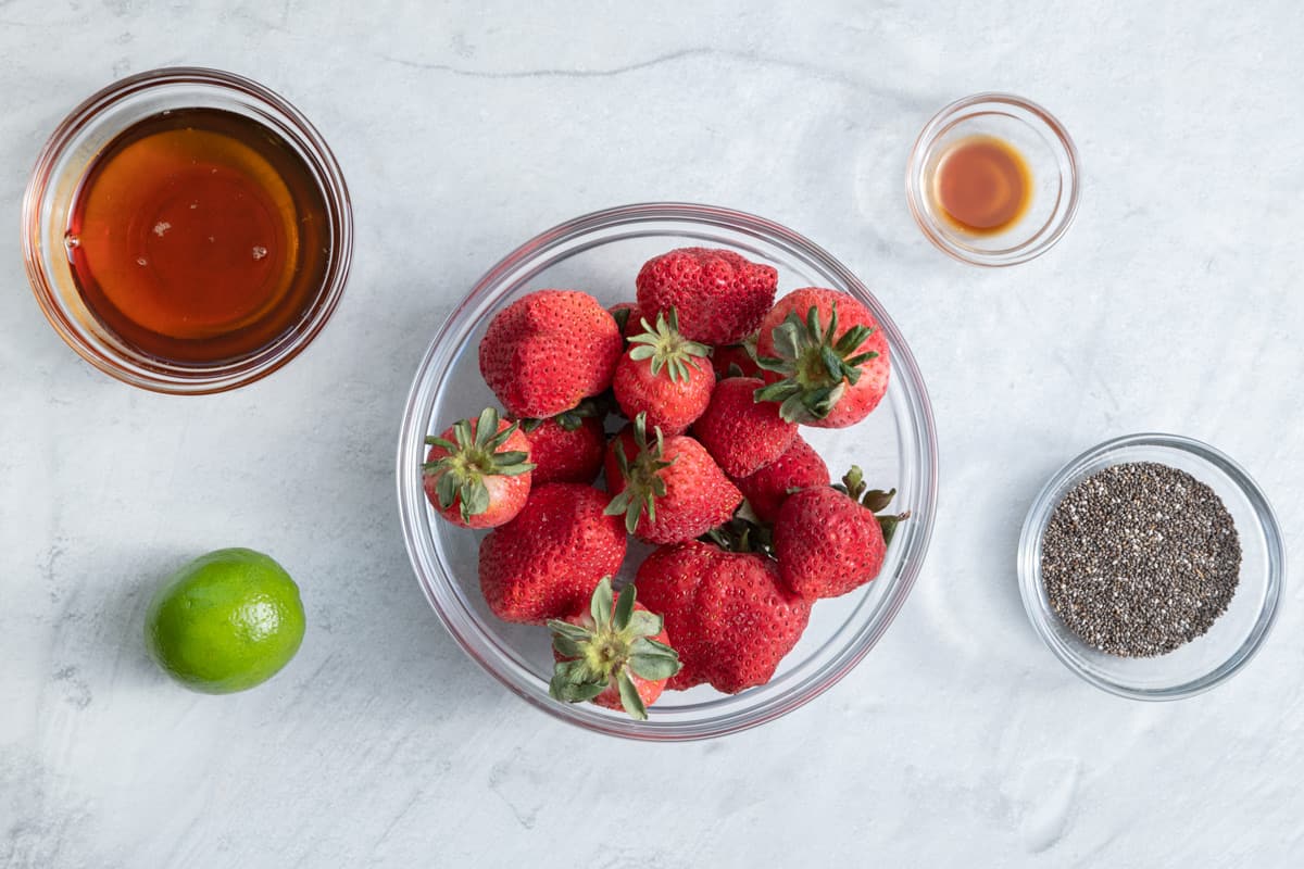 Ingredients to make the recipe: strawberries, maple syrup, chia seeds, vanilla & lime