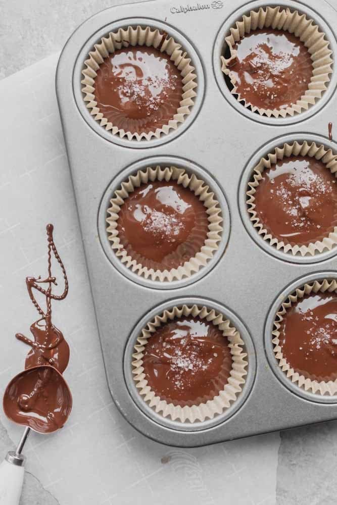 The chocolate pistachio butter cups after adding the top layer of melted chocolate.