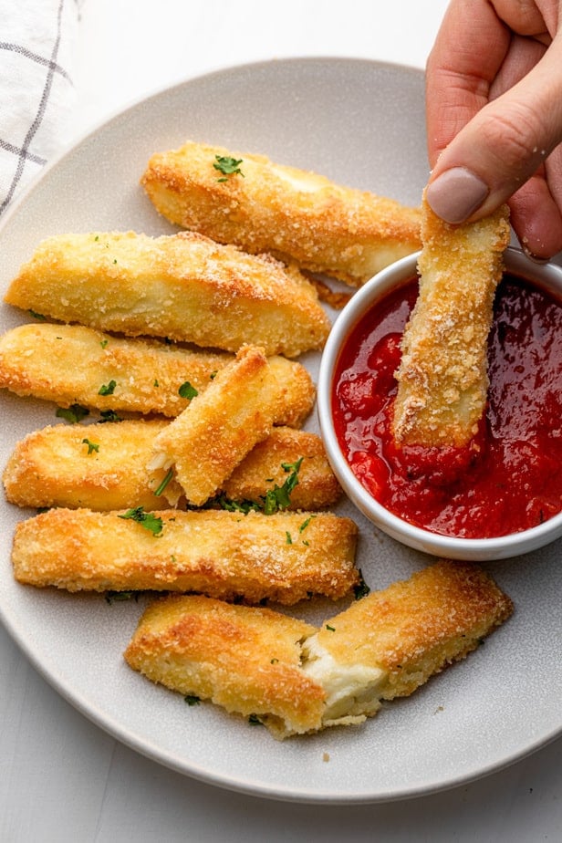 Halloumi fries coated in breading and dipped in marinara