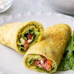 low carb egg wrap on a plate with sliced tomatoes
