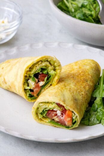 low carb egg wrap on a plate with sliced tomatoes