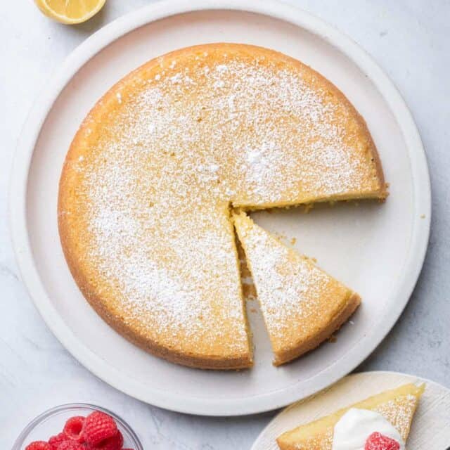 Large plate of olive oil cake with slice cut out on plate