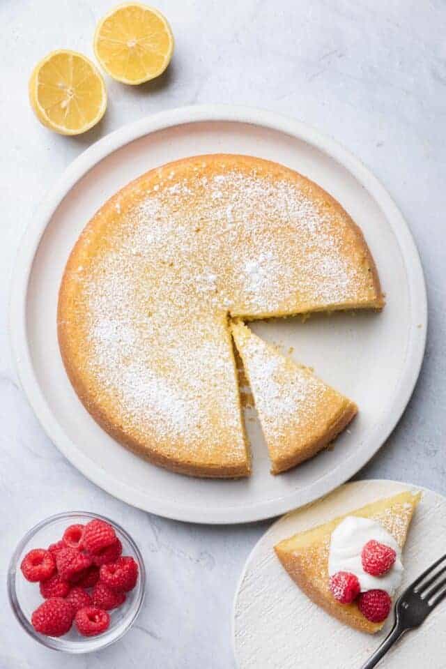 Large plate of olive oil cake with slice cut out on plate
