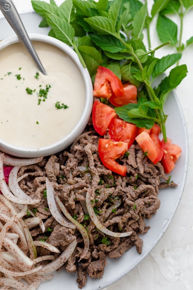 Beef shawarma close up shot with onions, tomatoes and parsley