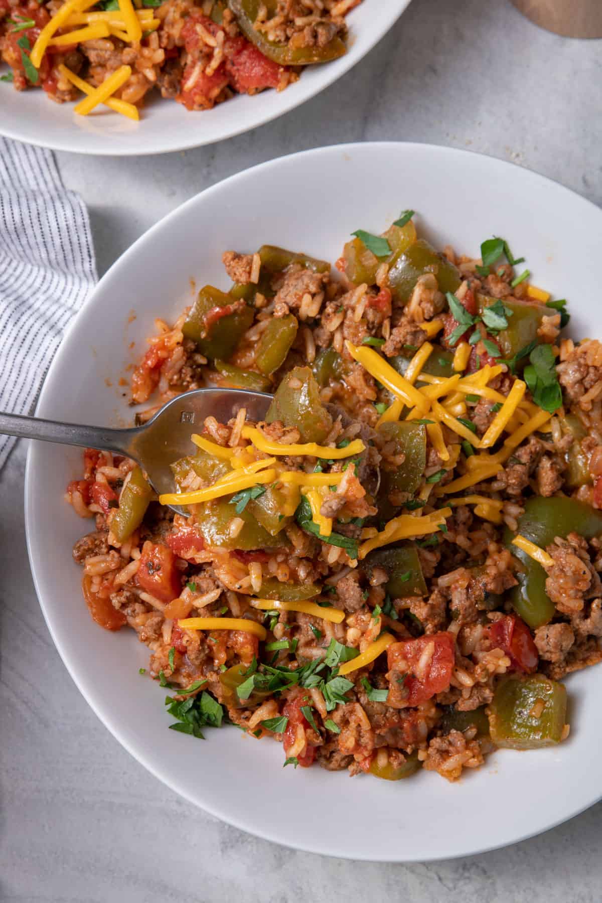 Large bowl of unstuffed peppers topped with shredded cheese