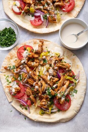 Thin Lebanese style pita bread topped with chicken shawarma, tahini sauce and vegetables