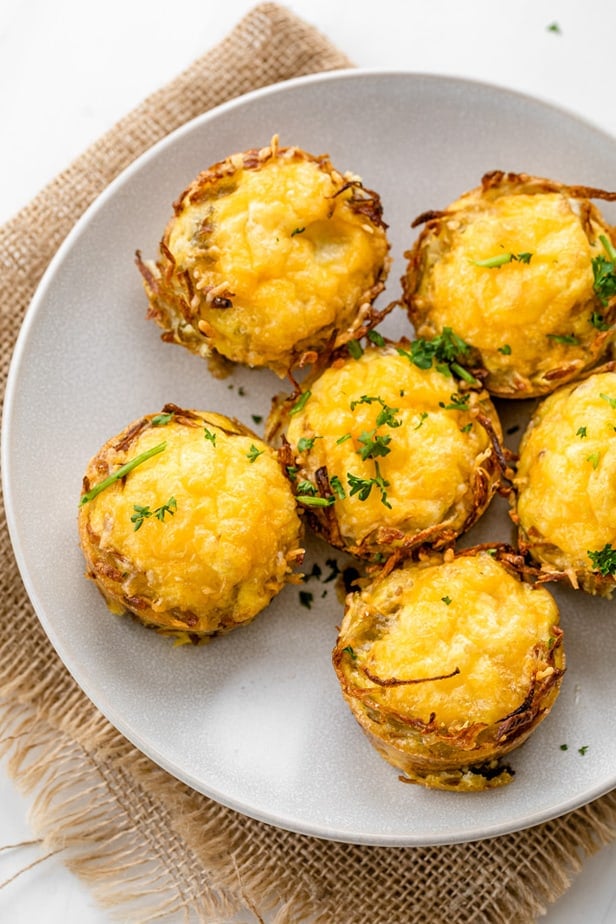 6 hash brown egg nests on a white plate