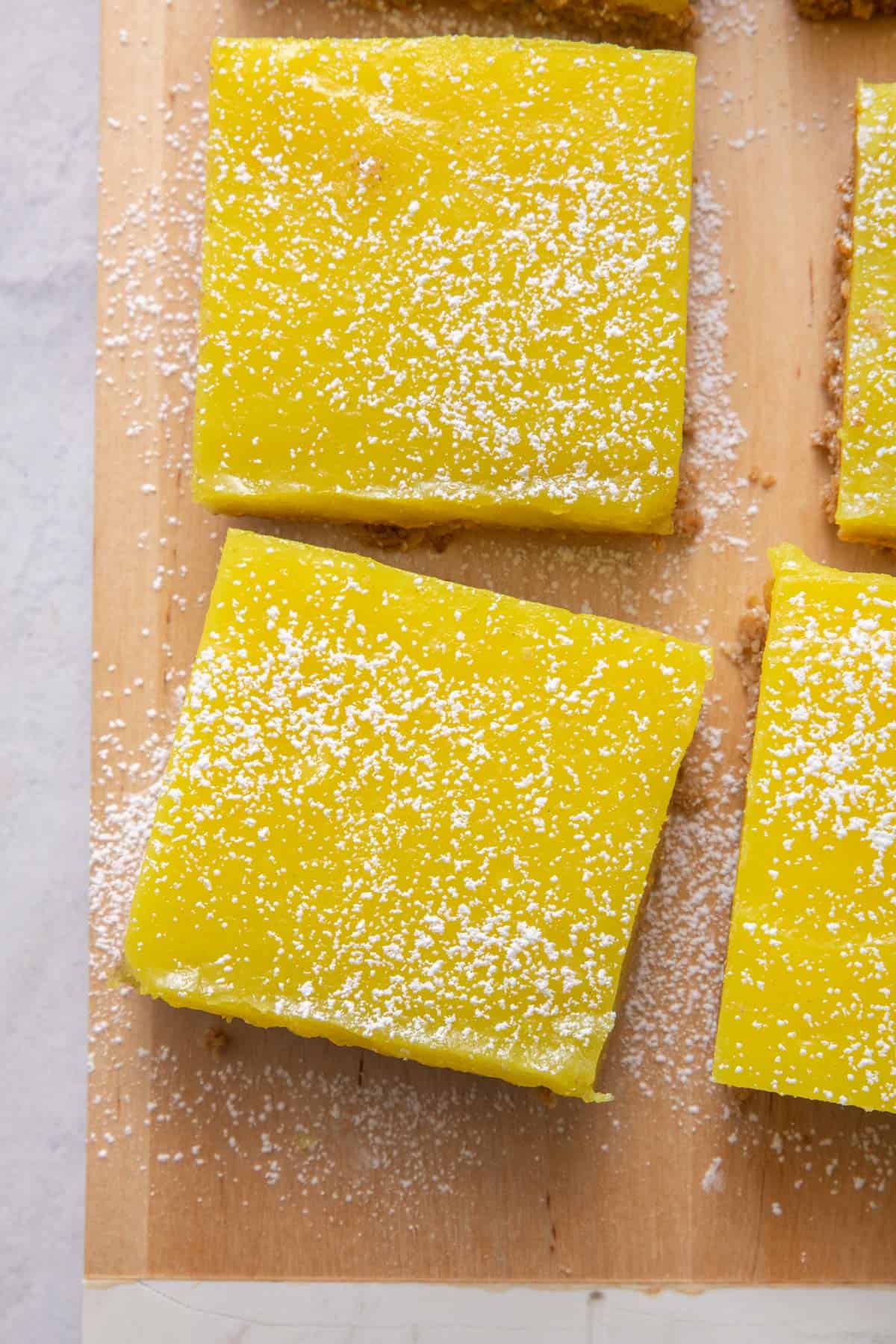 Close up shot of two lemon bars dusted with powdered sugar