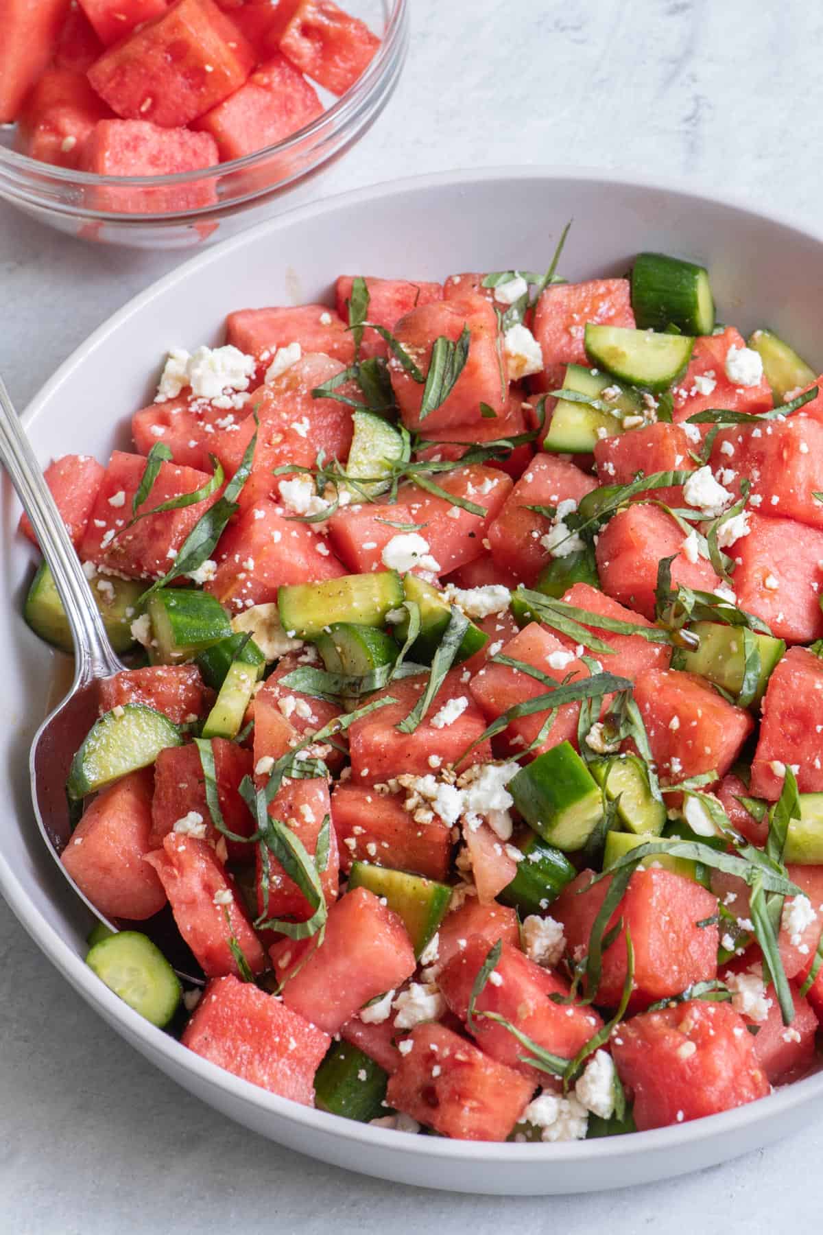 Watermelon Cucumber Salad in large serving bowl with spoon dipped in.