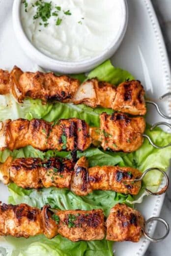 Shish tawook recipe on a platter with garlic sauce