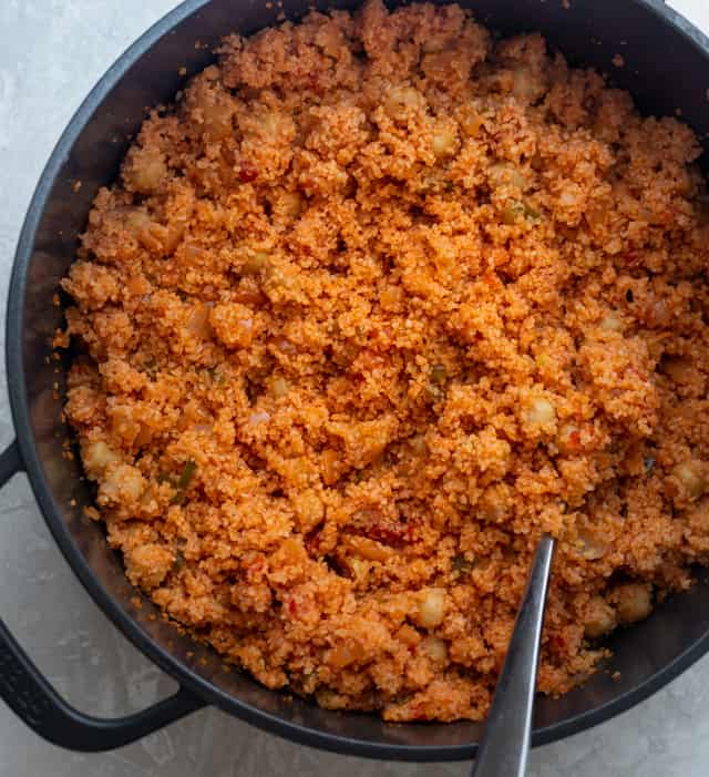 Fluffing the bulgur with a fork after it's done cooking