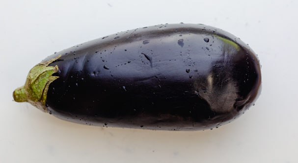 One large eggplant on a cutting board