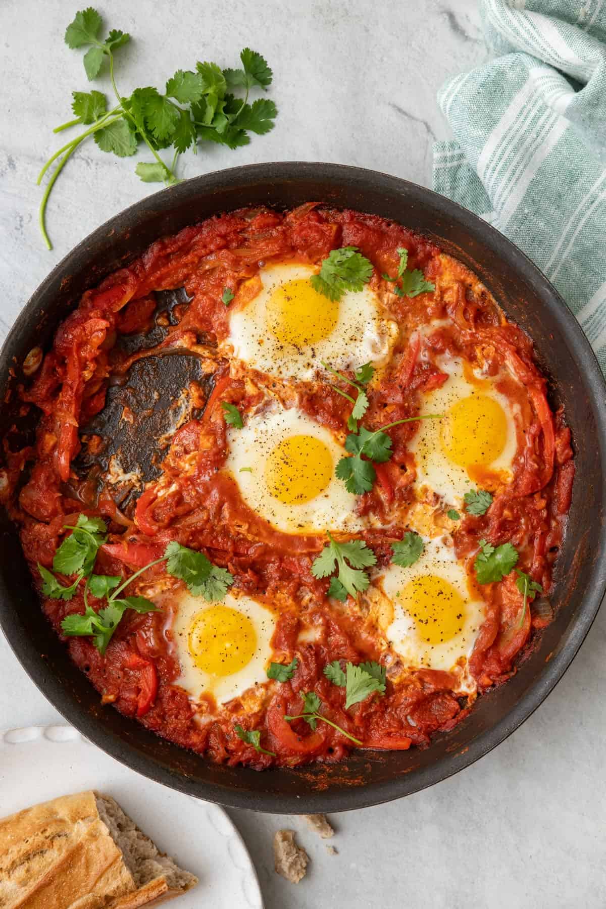 Pan of Shakshuka with a serving removed from the pan.