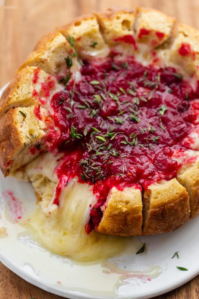 Baked brie cranberry with two bread pieces removed showing the