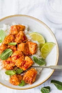 Close up of harissa chicken in a bowl with rice