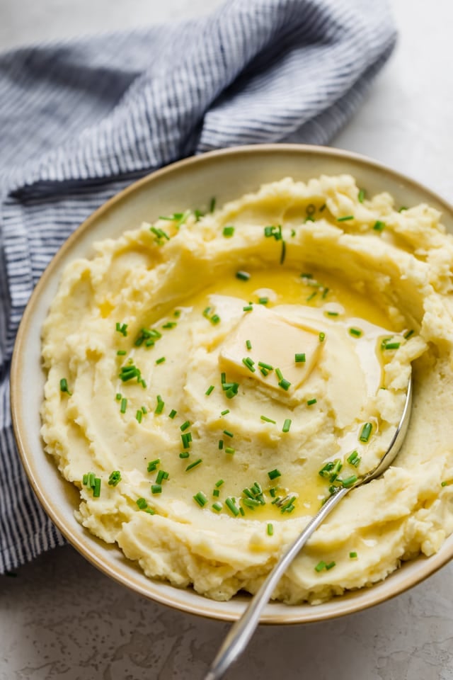 close up shot of healthy mashed potatoes with a large spoon in the potatoes for serving