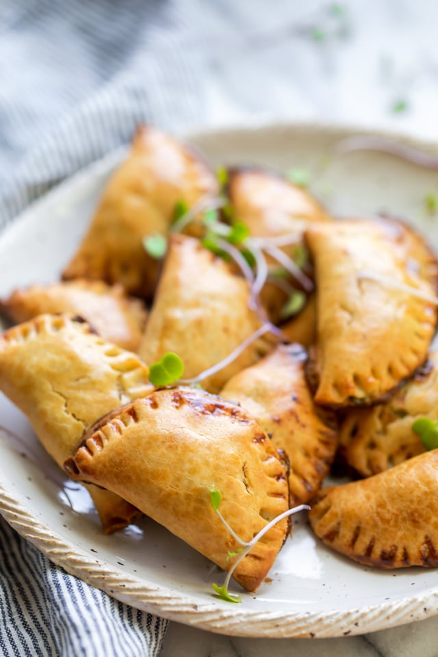 Broccoli and cheese hand pies on a white plate