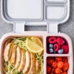 Lemon Garlic Chicken meal prep with zoodles, tomatoes and fruit