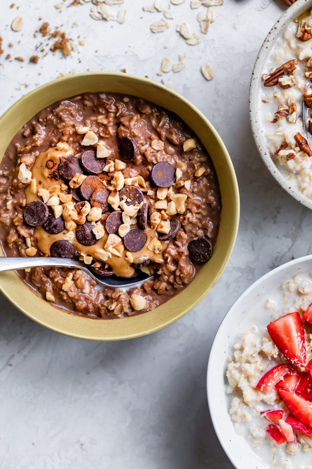 Three bowls of oatmeal with focus on the chocolate peanut butter oameal