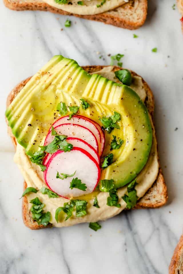 Hummus toast made with avocados, radishes and cilantro