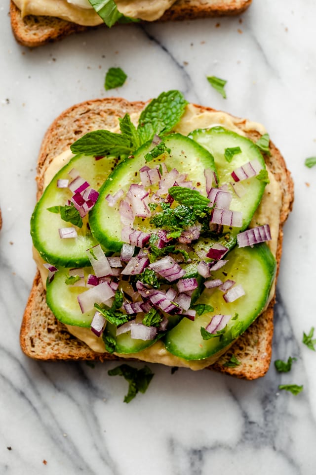 Hummus toast with cucumbers, red onions and mint