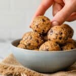 No bake energy bites with hand grabbing one from the top
