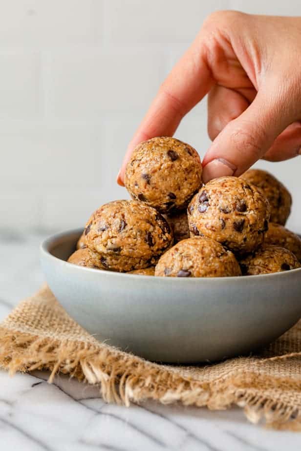 No bake energy bites with hand grabbing one from the top