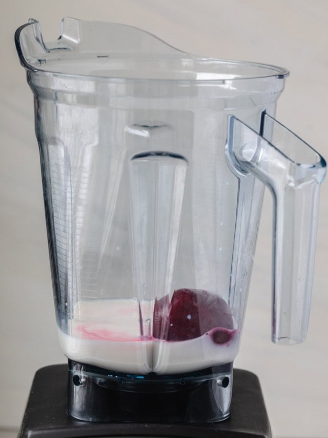 Cooked beet and milk in blender before blending.