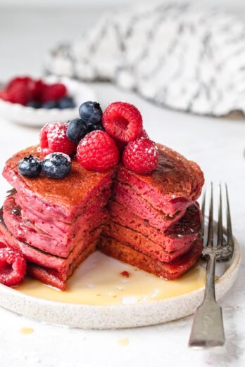Stack of pink pancakes cut with fork on the side