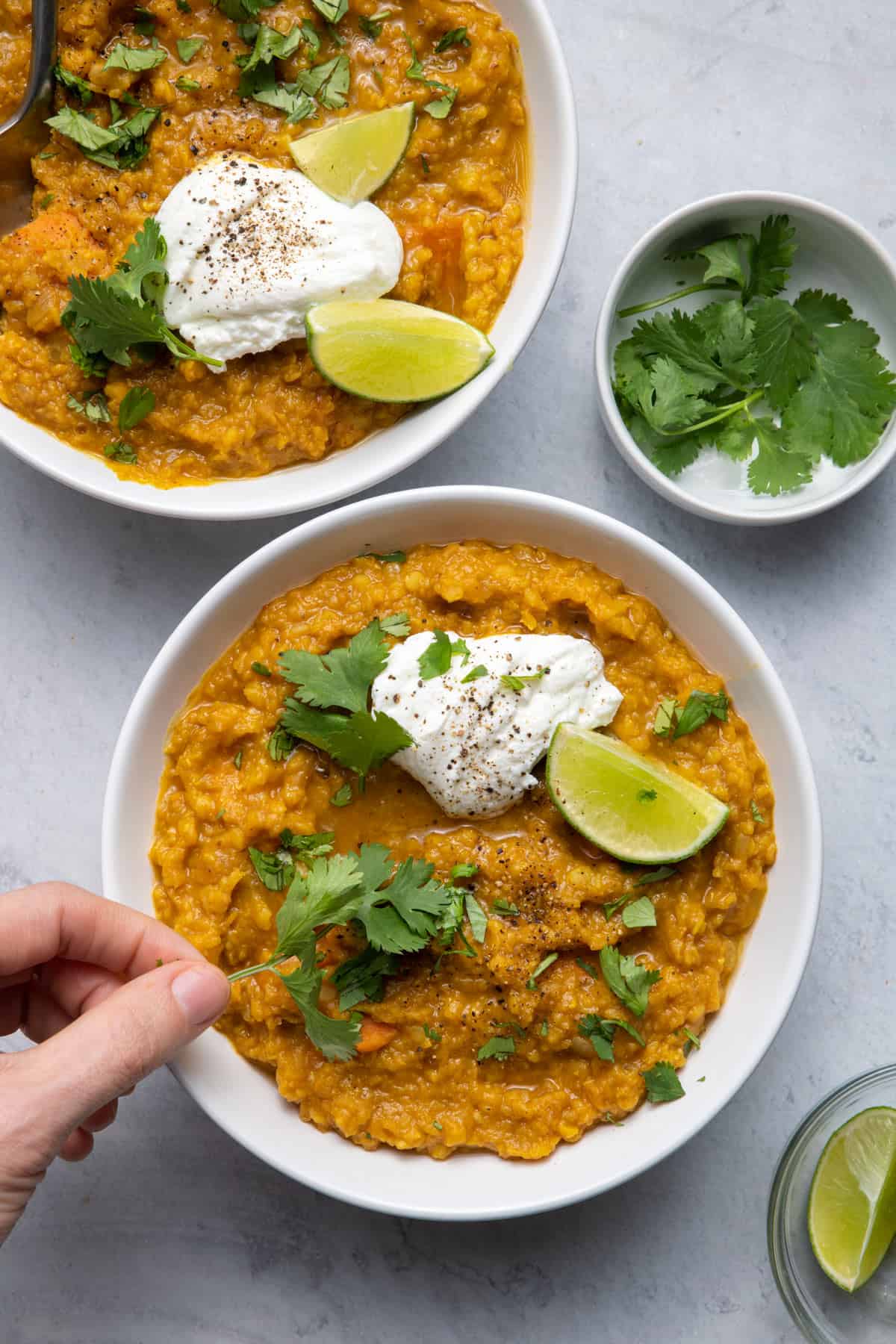 Close up shot of the final red lentil curry recipe plated in white bowls