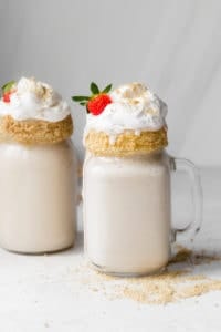 Final tahini milkshake recipe with cool whip, and strawberries and cookie frosted glasses