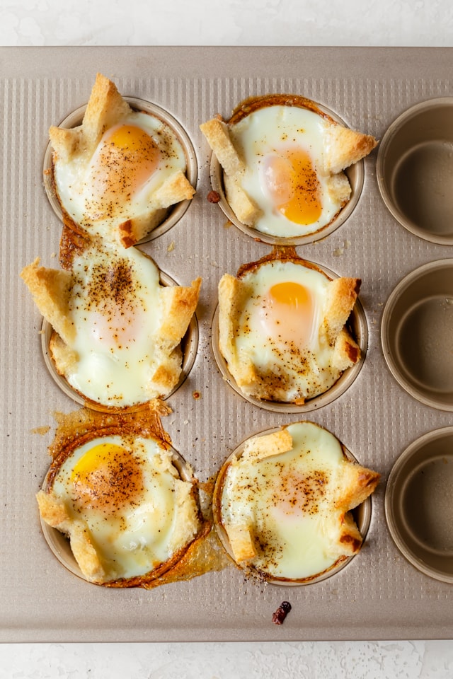 Final baked eggs in bread in muffin tin after removing from oven