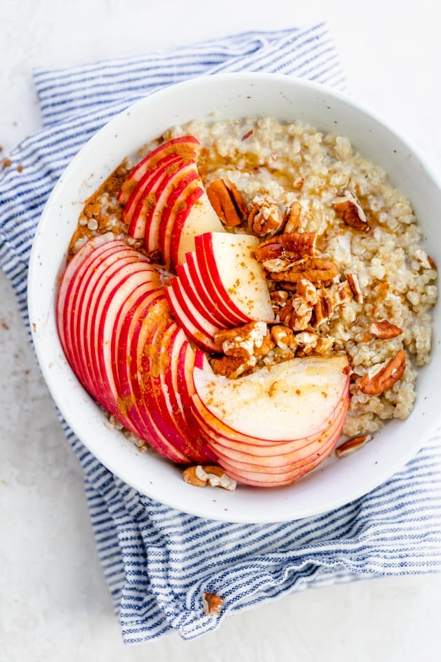Quinoa breakfast bowl with apples, pecans, cinnamon and maple syrup