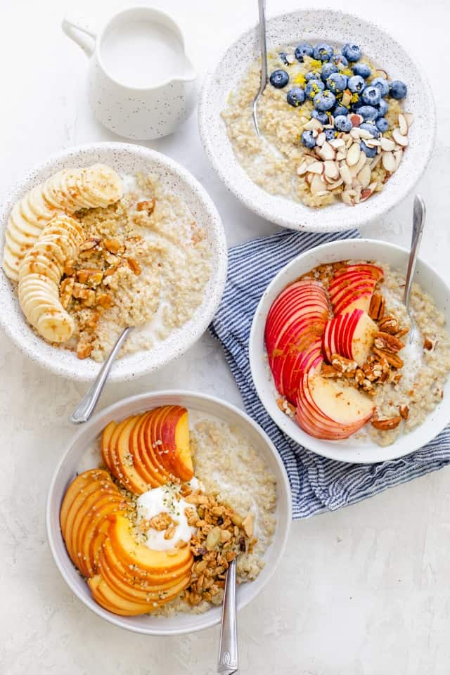 4 bowls of Quinoa oatmeal served with a variety of toppings for breakfast