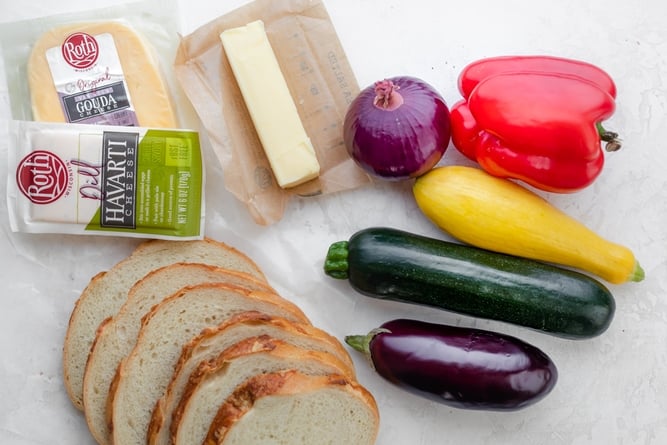 Ingredients to make grilled cheese sandwich - bread, Roth cheese, butter and assorted vegetables