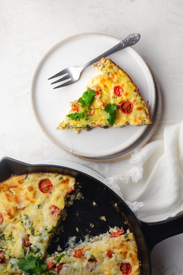Plate of one slice of vegetable frittata with a fork on the plate