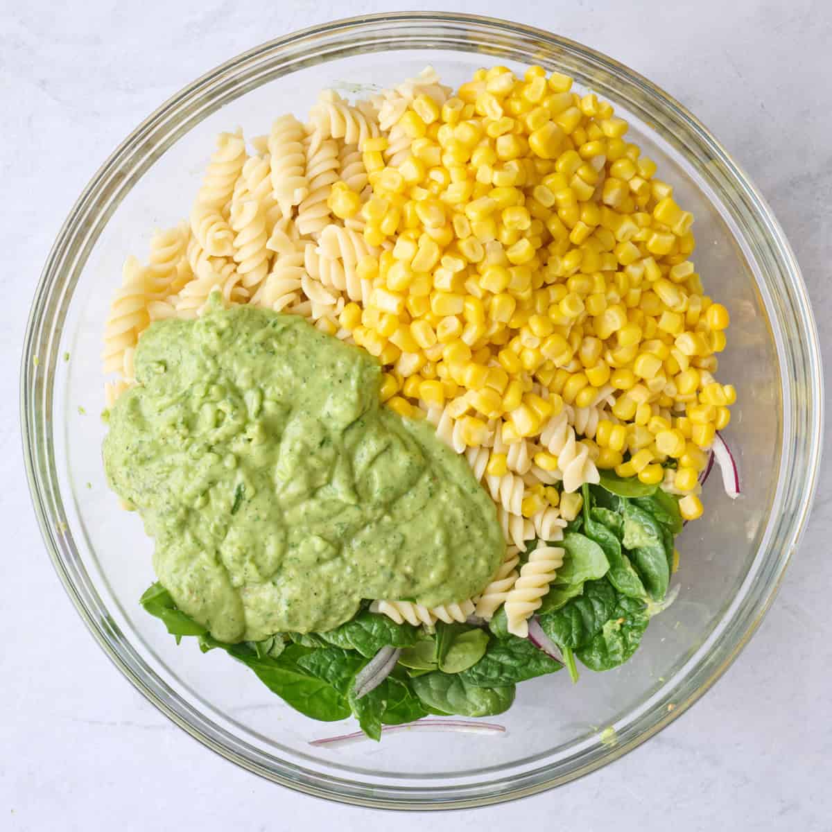 Cooked pasta, corn and dressing added before tossing together.