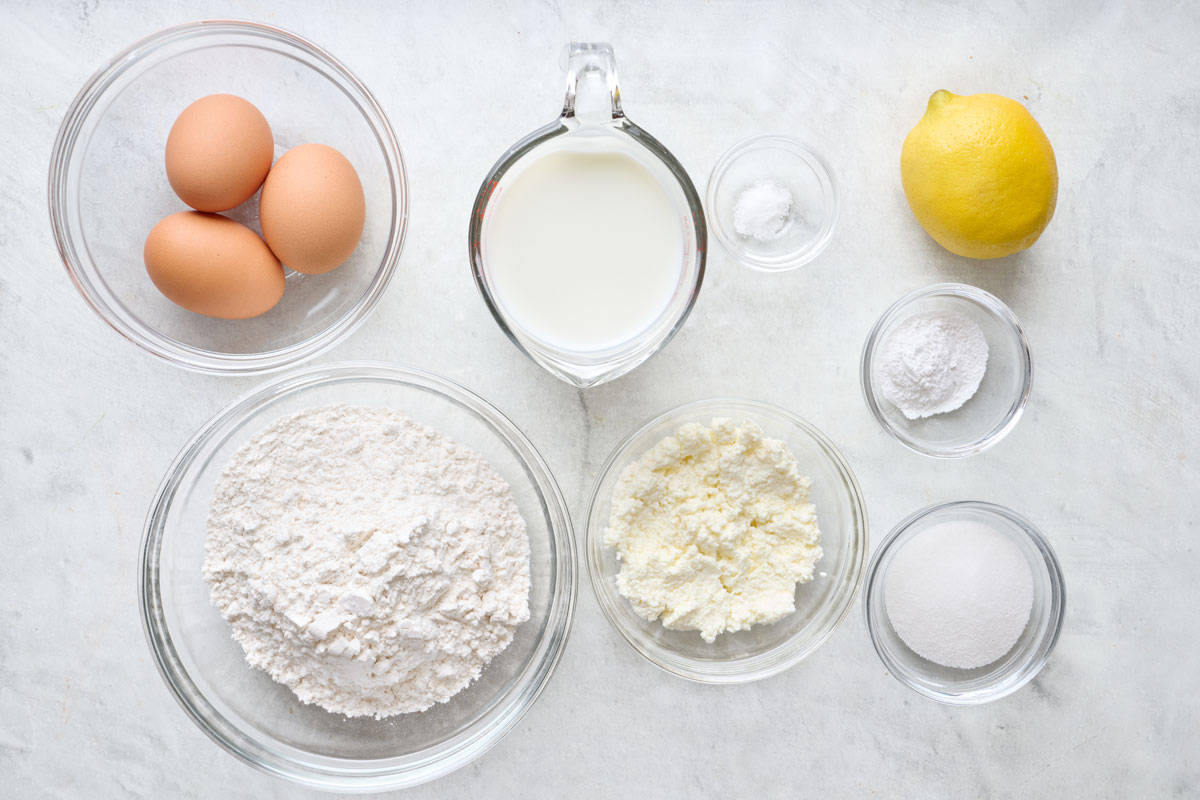 Ingredients for recipe: flour, sugar, baking powder, salt, milk, eggs, ricotta, and lemon.