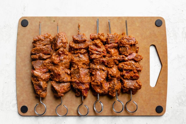 Cutting boards with the marinated kabobs skewered