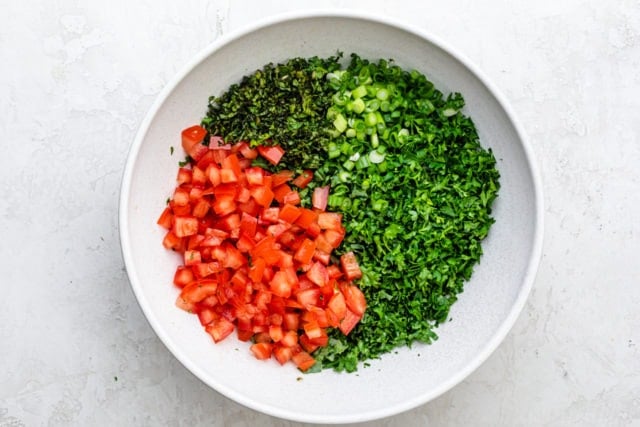 Large white bow with kale, parsley, mint, green onions and tomatoes 