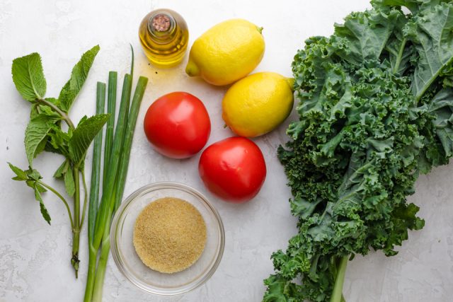 Ingredients to make the recipe: kale, tomatoes, lemons, olive oil, bulgur, green onions and mint