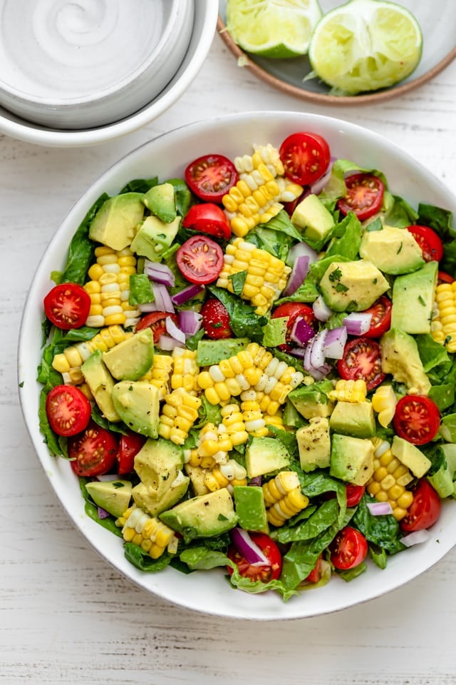 top down shot of summer salad with tomatoes, corn and avocado