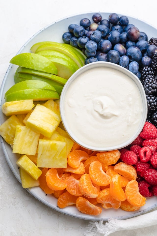 Cream cheese fruit dip surrounded by colorful fruits