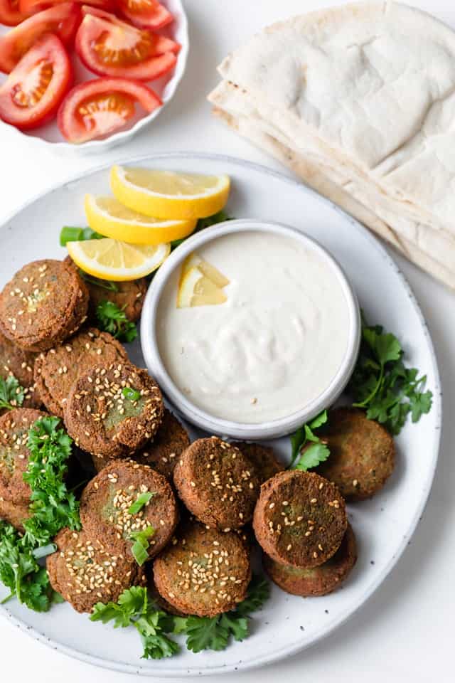 Falafel patties with falafel sauce, pita and tomatoes