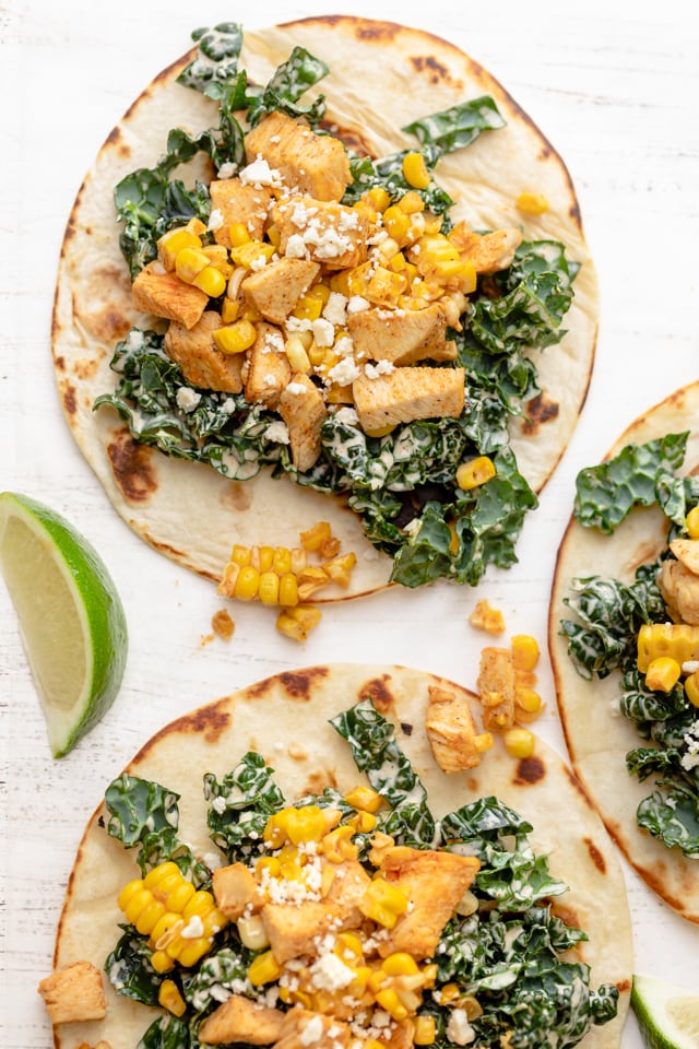 Flour tortillas topped with kale slaw, chicken, corn and cotija cheese 